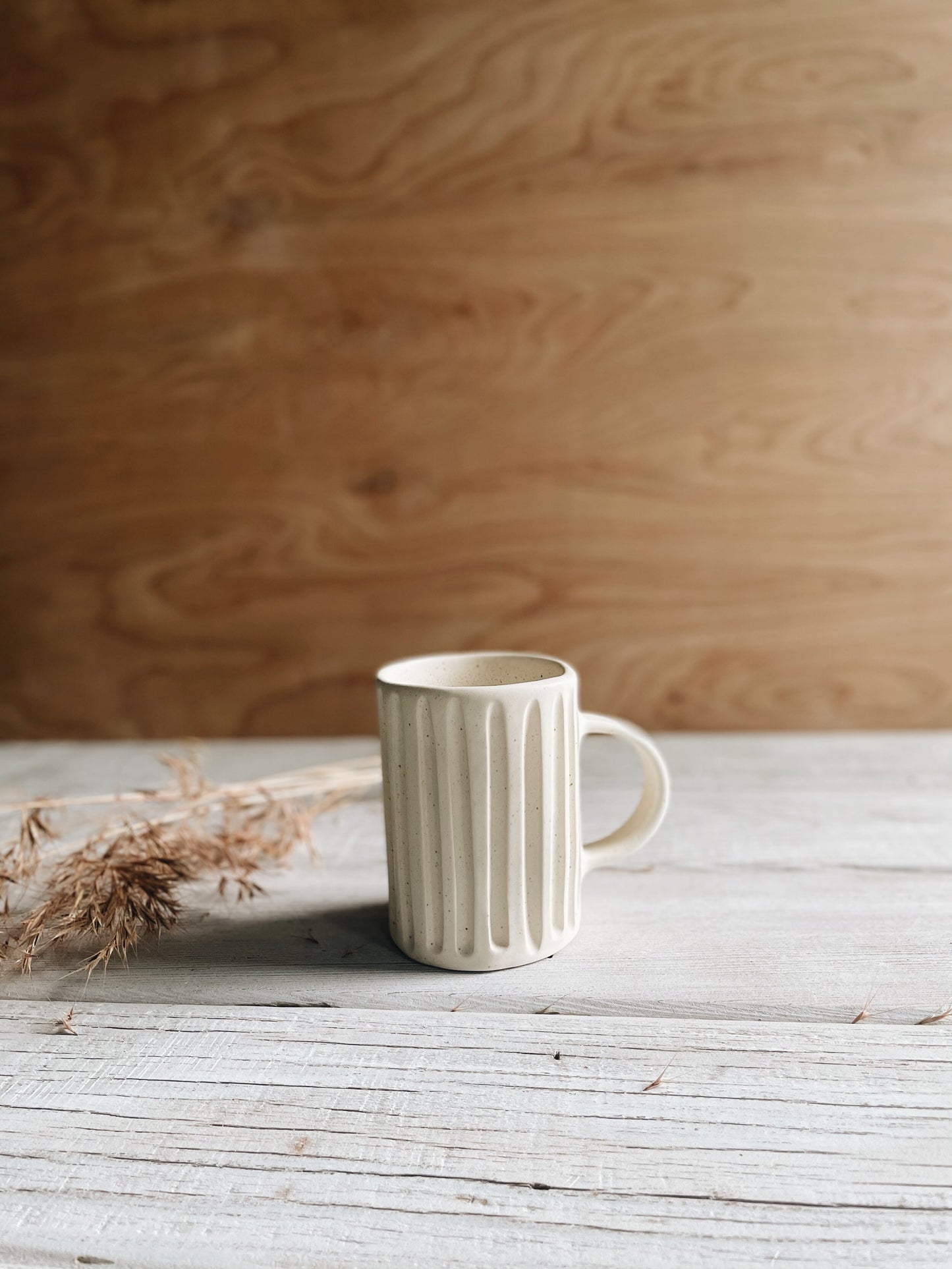 Lined ceramic mug with speckled effect and matte finish.