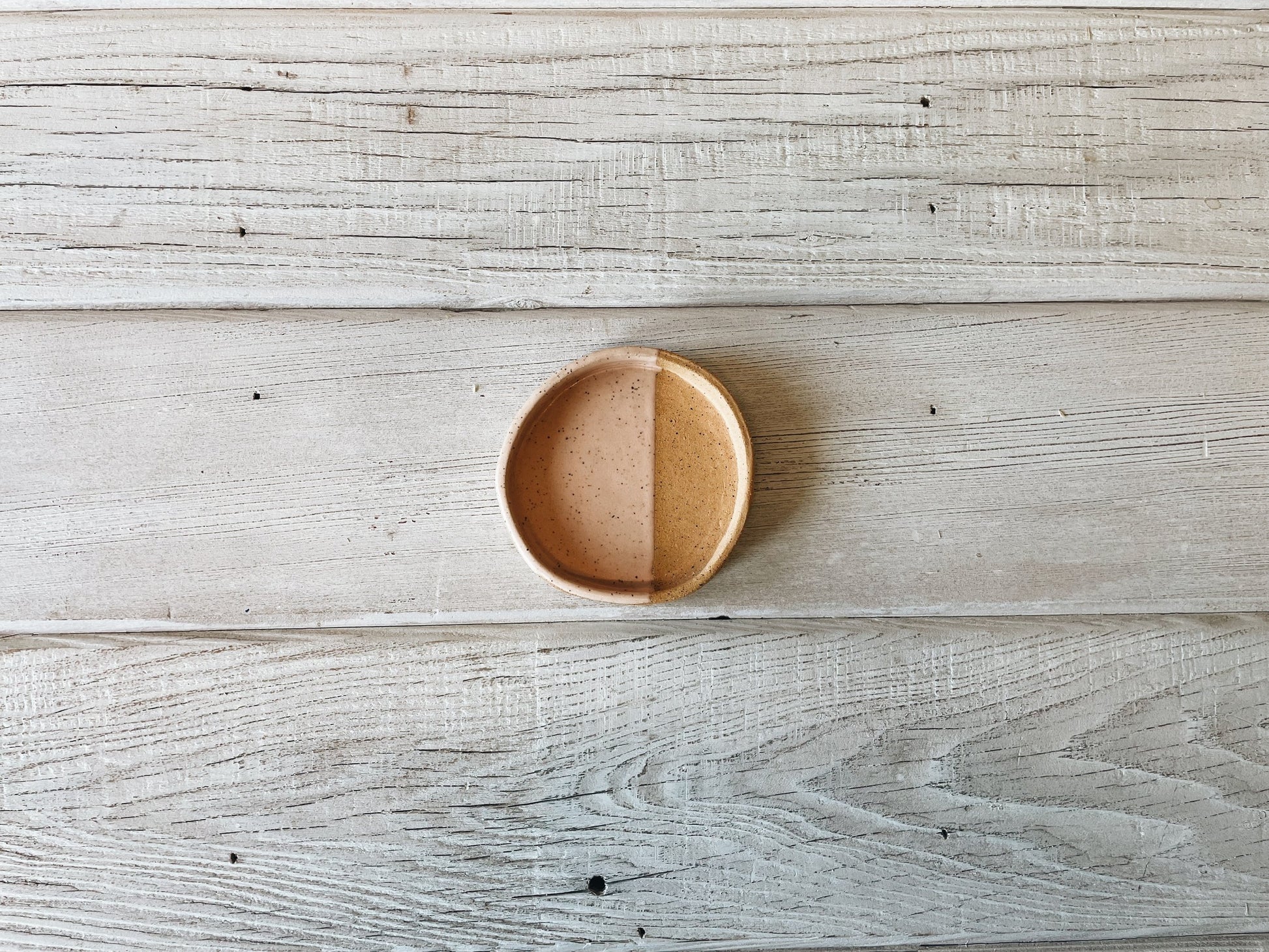 Half dipped ceramic dish on wooden table.