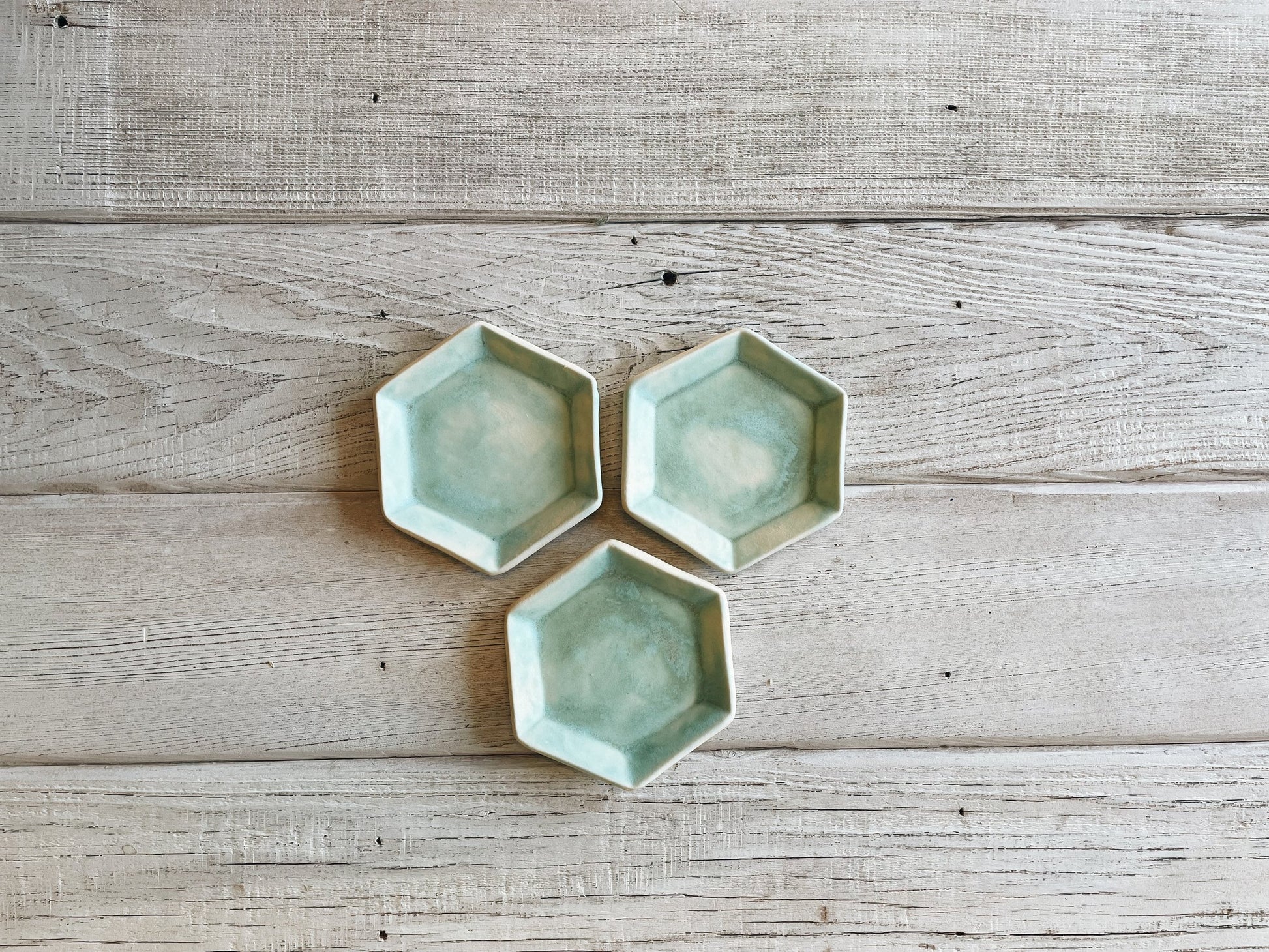 Three hexagon ceramic dishes in turquoise.