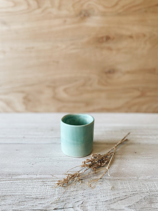 Small ceramic cup in turquoise.