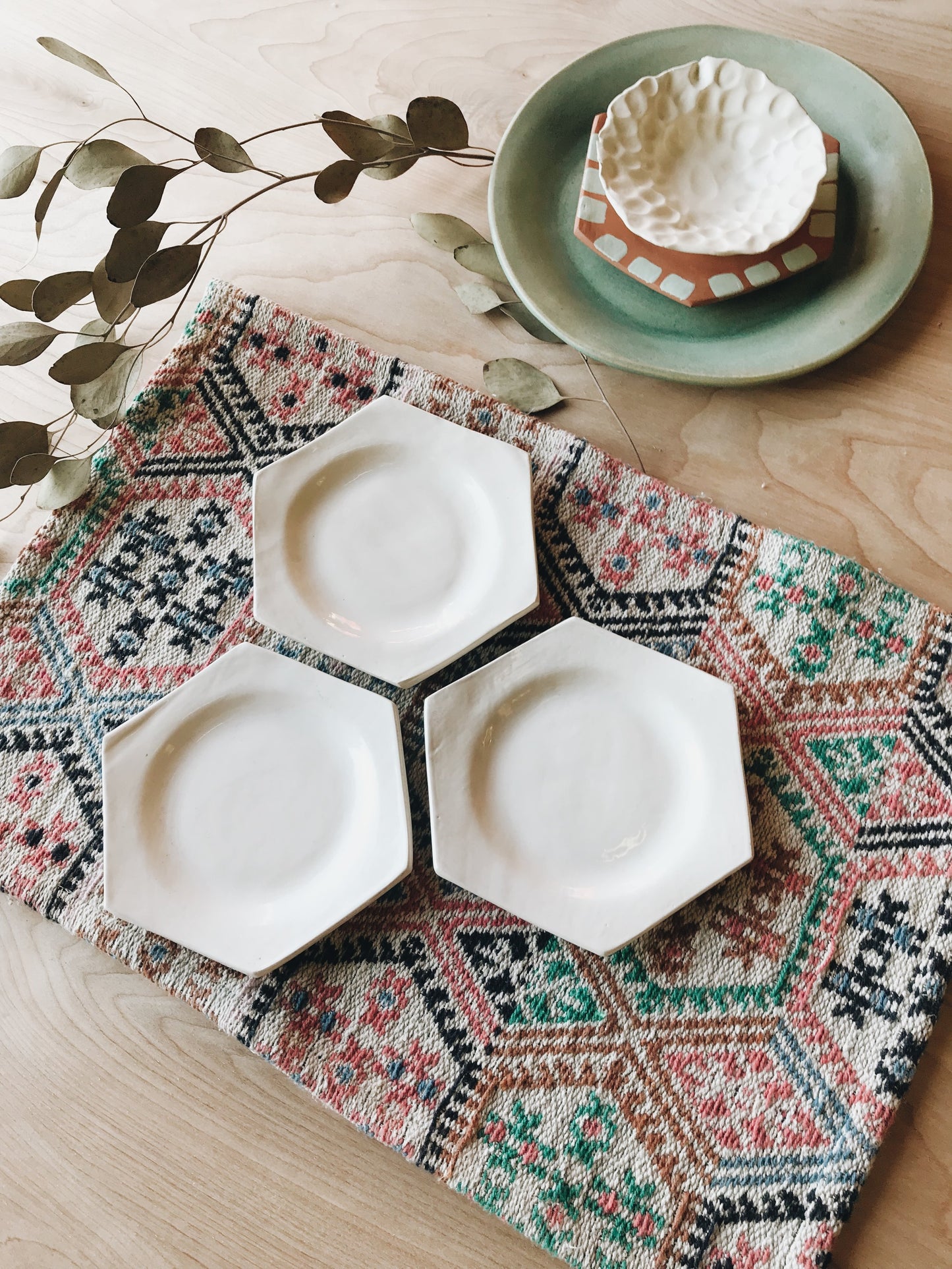 Set of three honeycomb ceramic dishes on place mat.